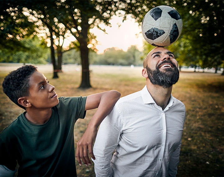 Un hombre disfruta demostrando su destreza balanceando un balón de fútbol en su cabeza.